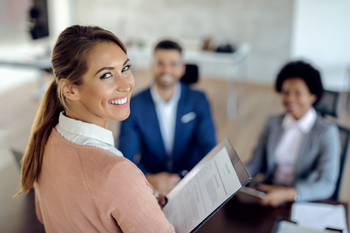 Profissional apresenta currículo em entrevista de emprego após aprender como fazer um currículo.