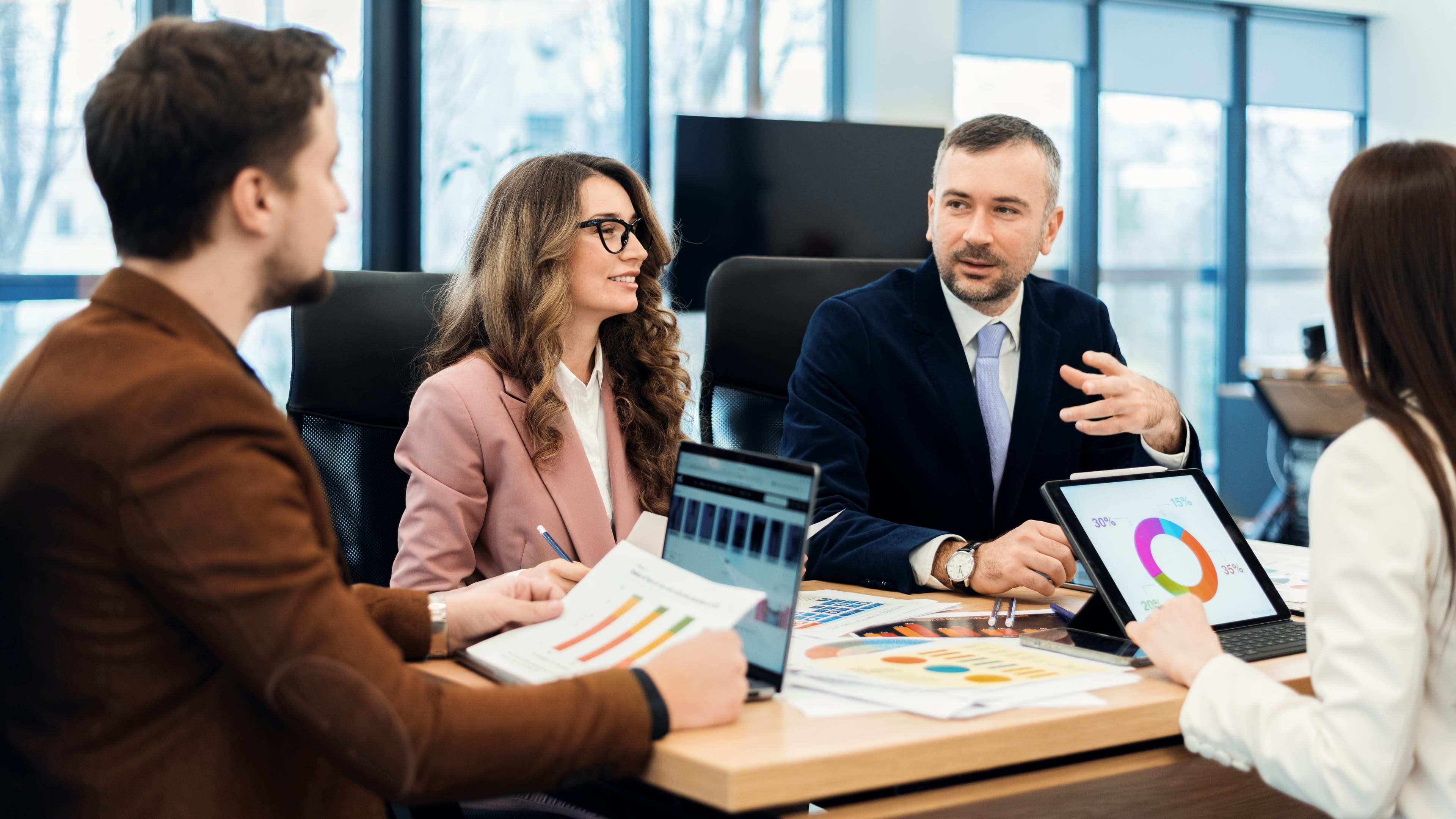 Executivos em reunião analisando gráficos e indicadores de alta performance executiva.